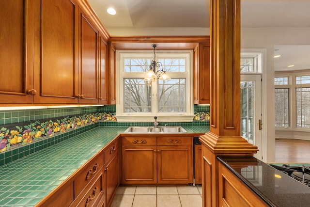 kitchen with sink, backsplash, a healthy amount of sunlight, and light tile patterned floors