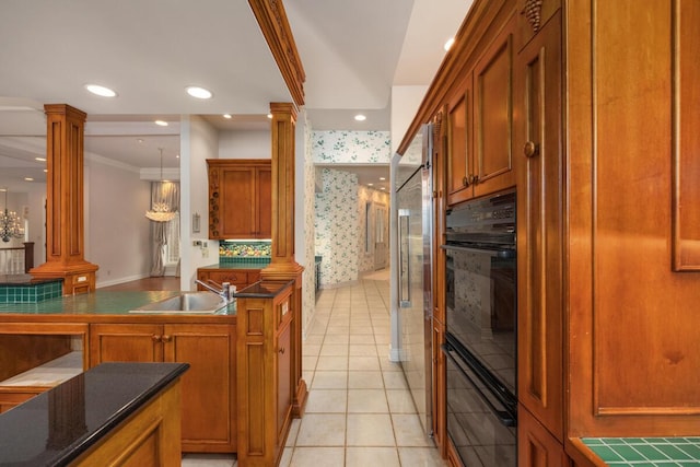 kitchen with decorative columns, black oven, high quality fridge, light tile patterned floors, and pendant lighting