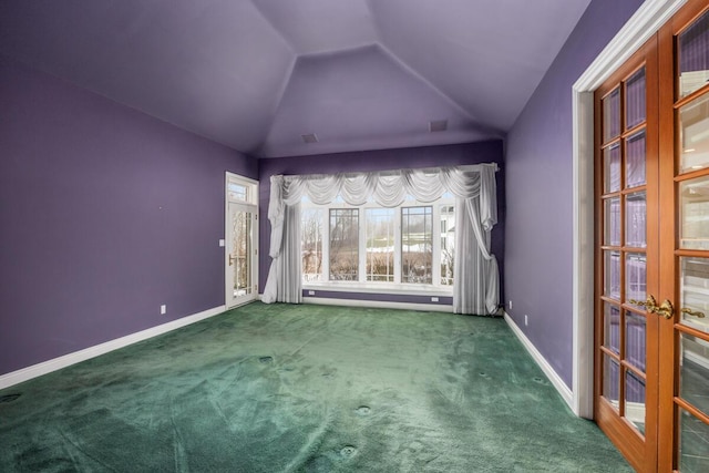 carpeted spare room with vaulted ceiling and french doors