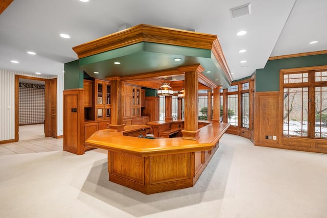 interior space featuring ornamental molding, ornate columns, and light carpet