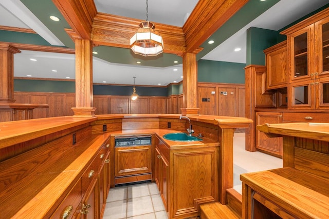 bar with butcher block countertops, sink, ornate columns, crown molding, and pendant lighting