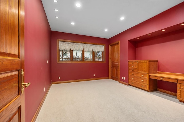 interior space with light carpet and built in desk