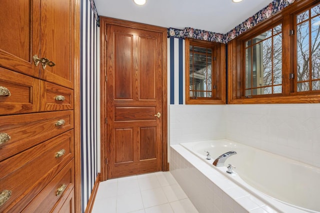 bathroom featuring tile patterned flooring and a relaxing tiled tub