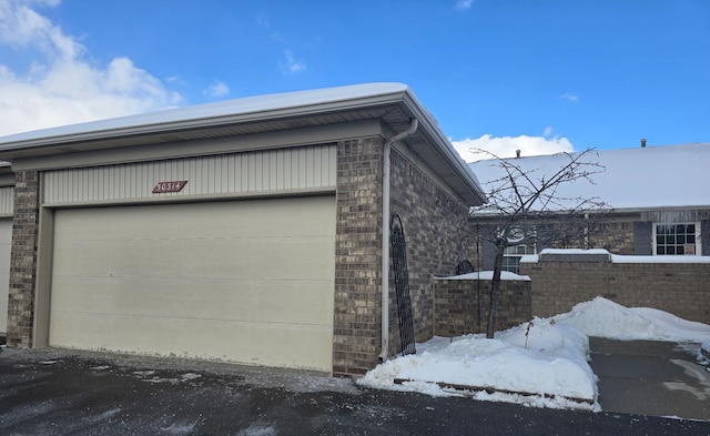 snow covered property with a garage