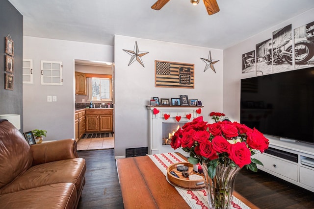 living area featuring dark wood-style flooring, visible vents, and ceiling fan