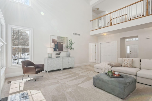 carpeted living room with a high ceiling