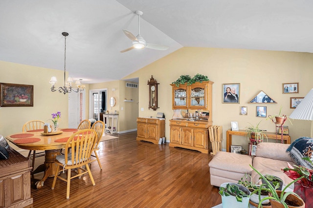 dining area with ceiling fan with notable chandelier, lofted ceiling, and dark hardwood / wood-style flooring