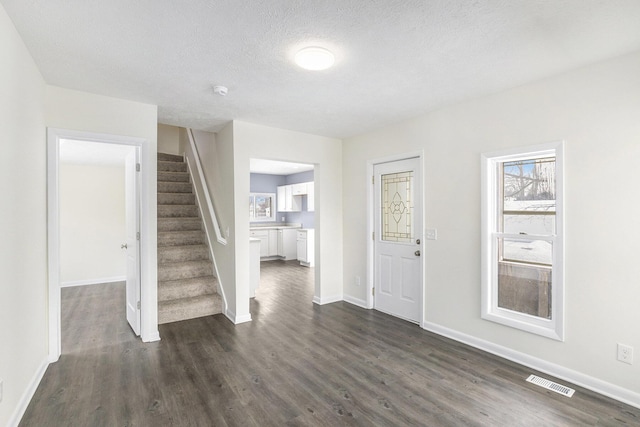 entryway with a textured ceiling and dark hardwood / wood-style floors