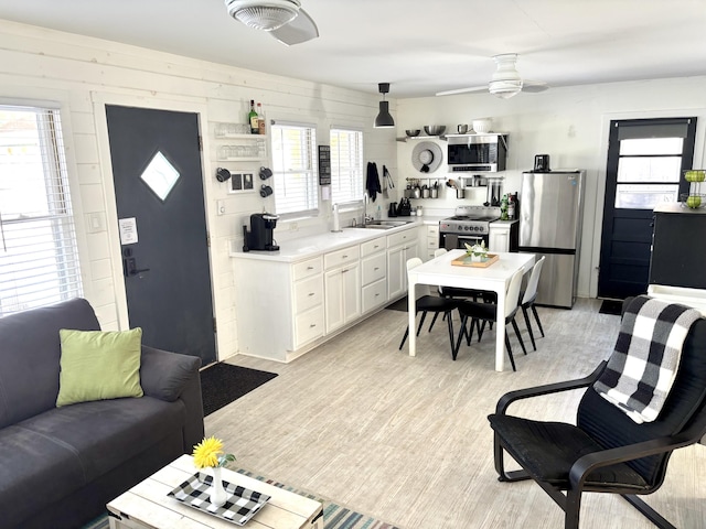 kitchen featuring ceiling fan, a sink, white cabinets, light countertops, and appliances with stainless steel finishes