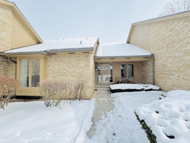 view of snow covered rear of property