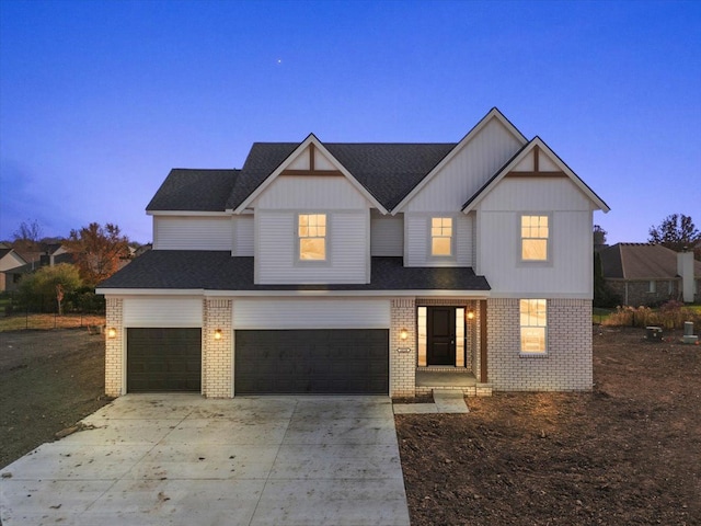 view of front of home with a garage, concrete driveway, and brick siding