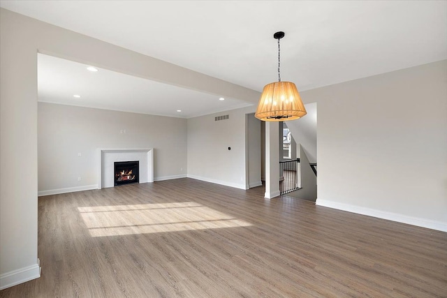 unfurnished living room with recessed lighting, dark wood finished floors, and baseboards