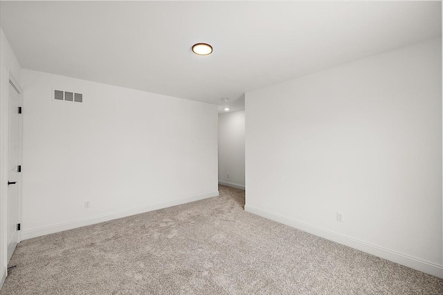 unfurnished room featuring baseboards, visible vents, and light colored carpet