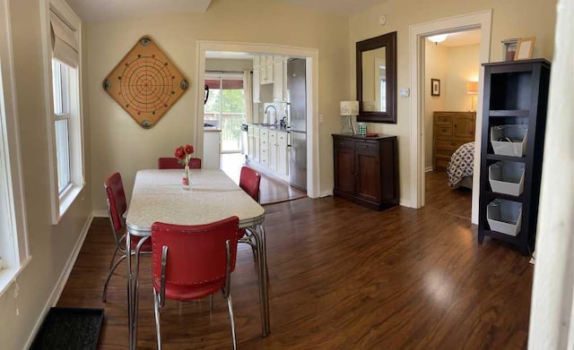 dining area with dark hardwood / wood-style flooring and sink