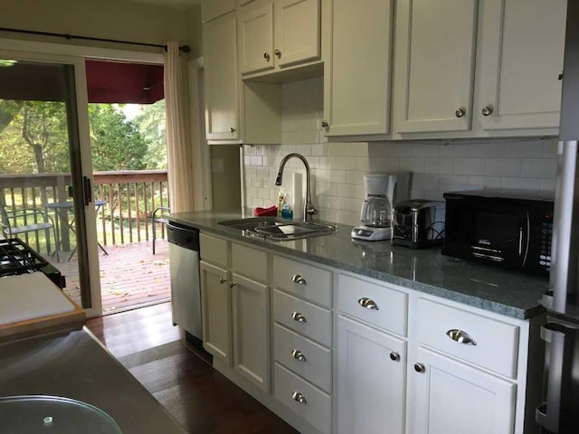 kitchen with white cabinets, stone counters, stainless steel dishwasher, sink, and dark hardwood / wood-style floors