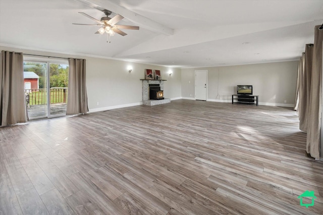 unfurnished living room featuring baseboards, lofted ceiling with beams, crown molding, light wood-style floors, and a fireplace