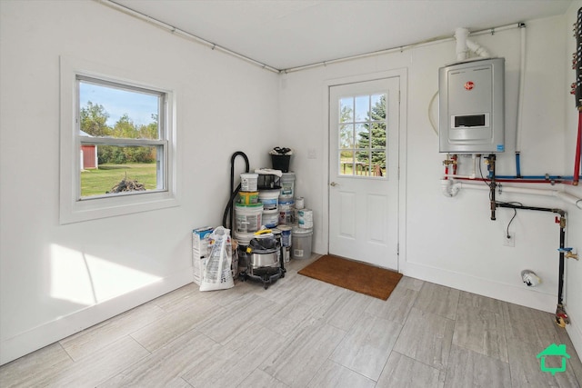 interior space featuring a wealth of natural light, water heater, and baseboards