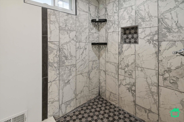 interior details featuring visible vents and a tile shower