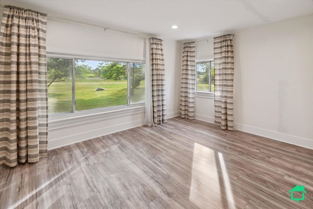 unfurnished room with recessed lighting, light wood-style flooring, and baseboards