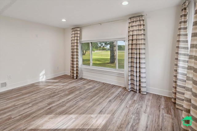 unfurnished room featuring light wood finished floors, visible vents, baseboards, and recessed lighting