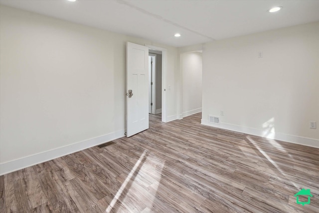 spare room featuring baseboards, light wood-type flooring, visible vents, and recessed lighting