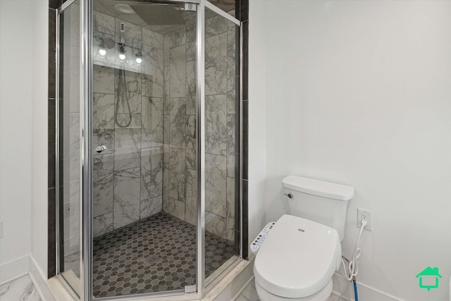 bathroom with marble finish floor, a stall shower, toilet, and baseboards