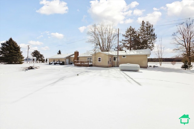 view of snow covered back of property