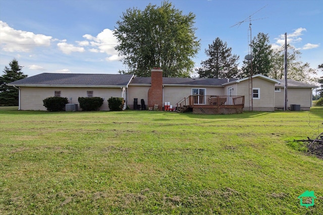 rear view of property featuring a wooden deck, a chimney, central AC, and a yard