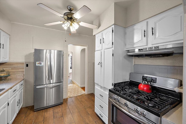 kitchen featuring under cabinet range hood, light countertops, dark wood finished floors, white cabinets, and stainless steel appliances