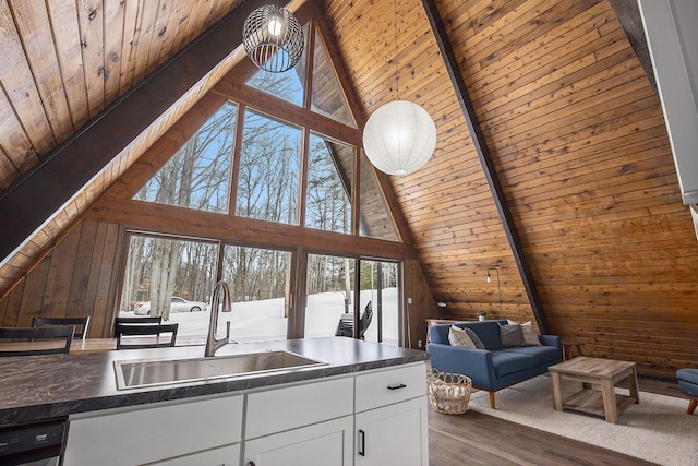 interior space with hanging light fixtures, white cabinets, wood ceiling, dark hardwood / wood-style flooring, and sink