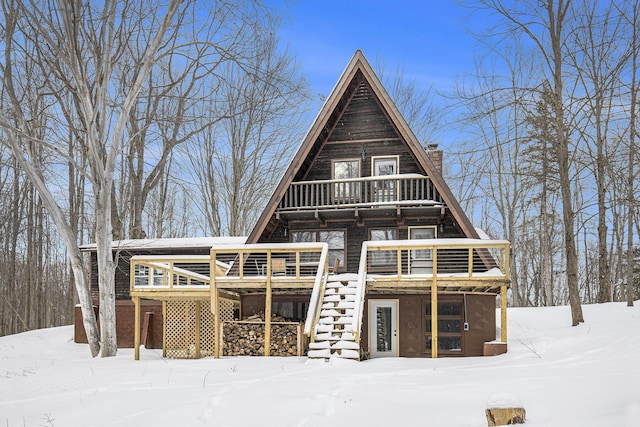 snow covered house featuring a wooden deck