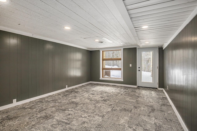 empty room with carpet flooring and wood walls