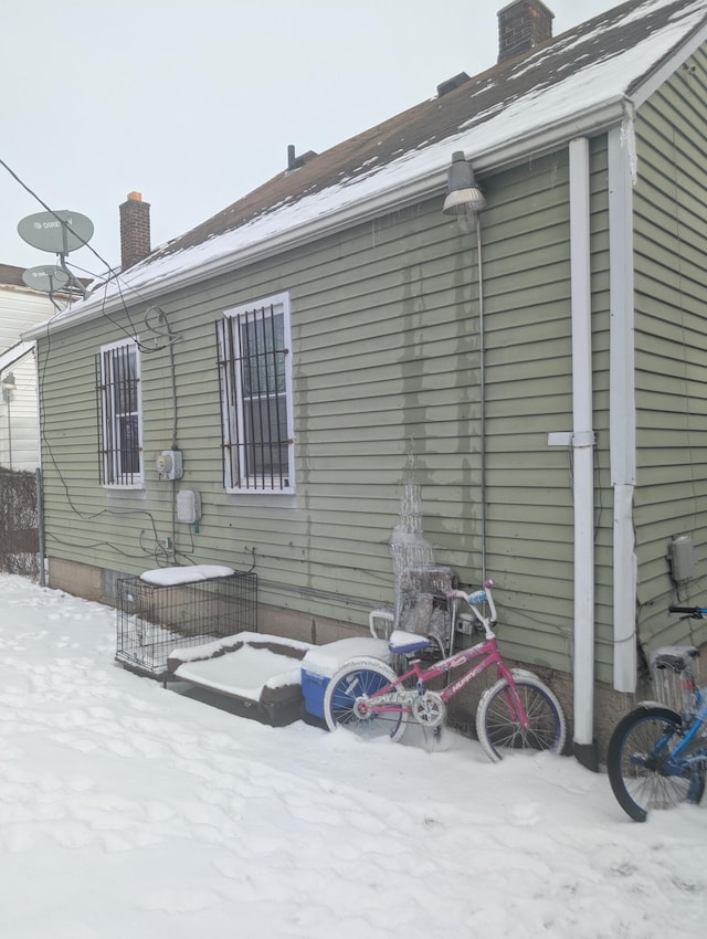 view of snow covered rear of property