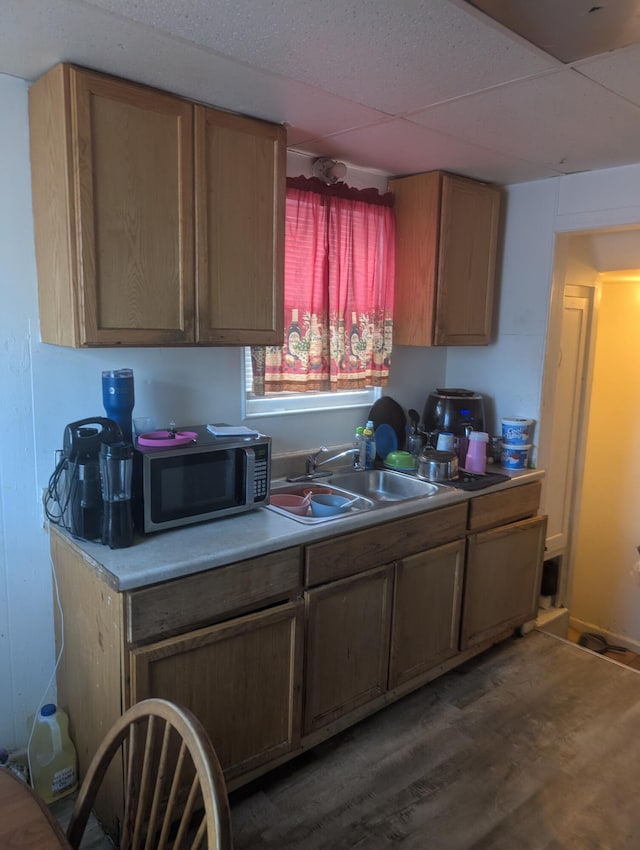 kitchen featuring sink, dark hardwood / wood-style flooring, and a drop ceiling