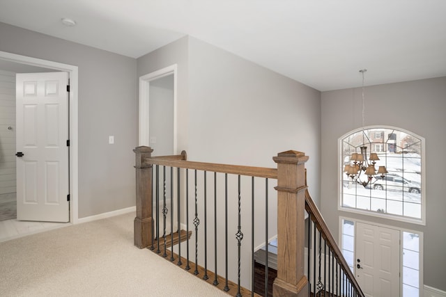 hallway featuring an inviting chandelier and carpet floors