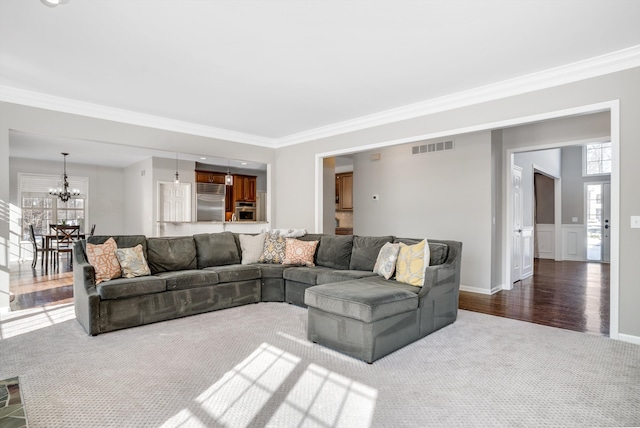 living room featuring ornamental molding, an inviting chandelier, and hardwood / wood-style floors