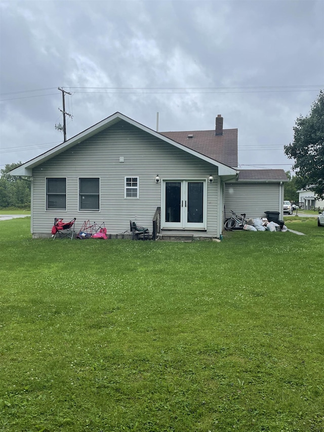 back of property featuring a yard and french doors