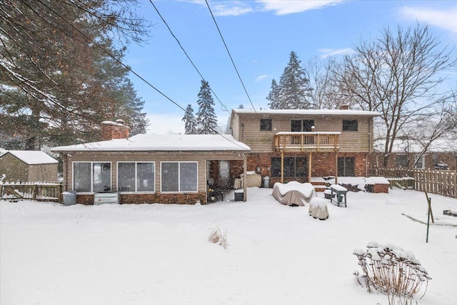 snow covered house featuring a balcony