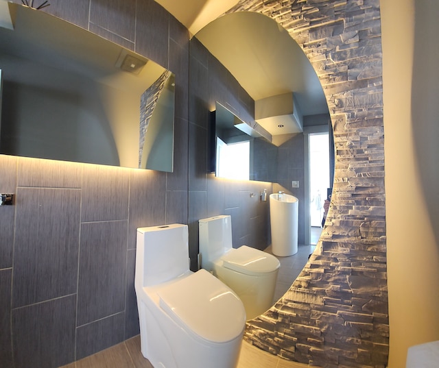 bathroom with tile walls and toilet