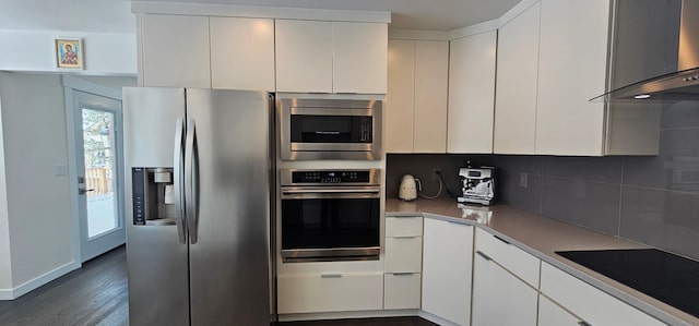 kitchen featuring backsplash, dark hardwood / wood-style floors, stainless steel appliances, wall chimney exhaust hood, and white cabinets