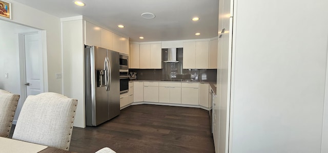 kitchen featuring backsplash, white cabinetry, wall chimney range hood, stainless steel appliances, and dark hardwood / wood-style flooring