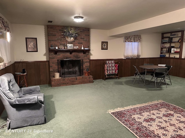 carpeted living room with a brick fireplace and wooden walls