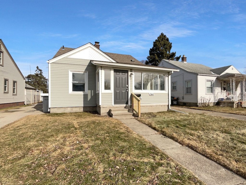 bungalow-style home with a front yard