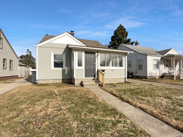 bungalow-style home with a front yard