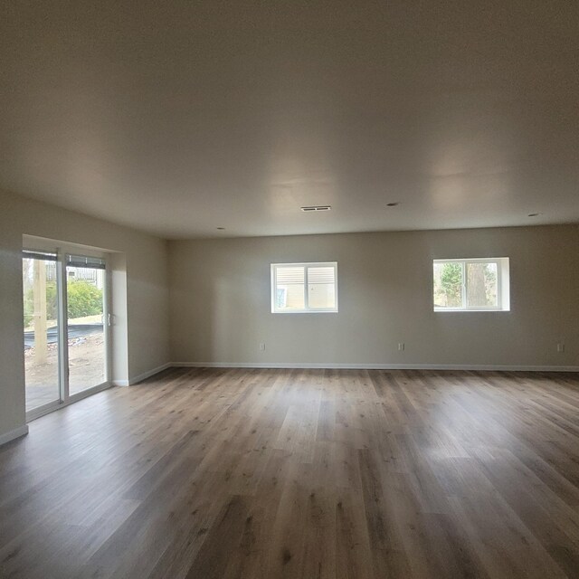 10781 Woodbrook Dr, Cement City, MI 49233 - empty room featuring plenty of natural light and wood finished floors