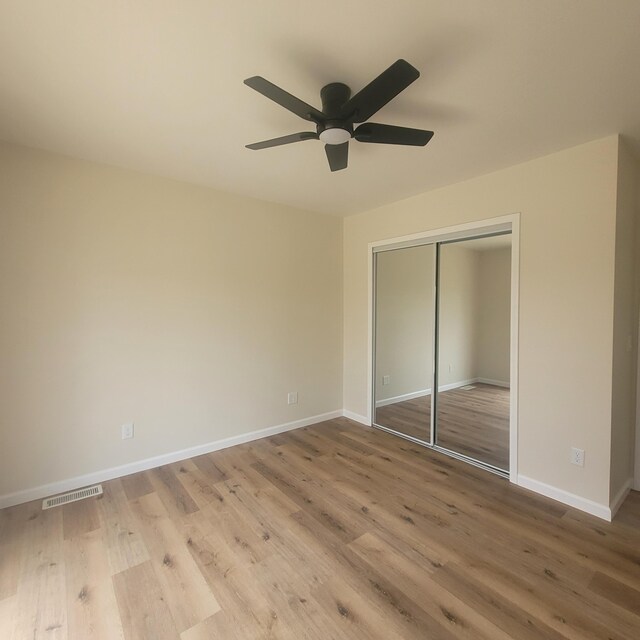 10781 Woodbrook Dr, Cement City, MI 49233 - unfurnished bedroom featuring wood finished floors, a closet, and a ceiling fan