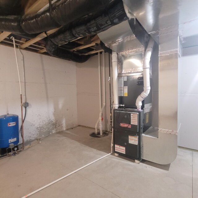 10781 Woodbrook Dr, Cement City, MI 49233 - unfinished below grade area featuring a water pressure tank and heating unit