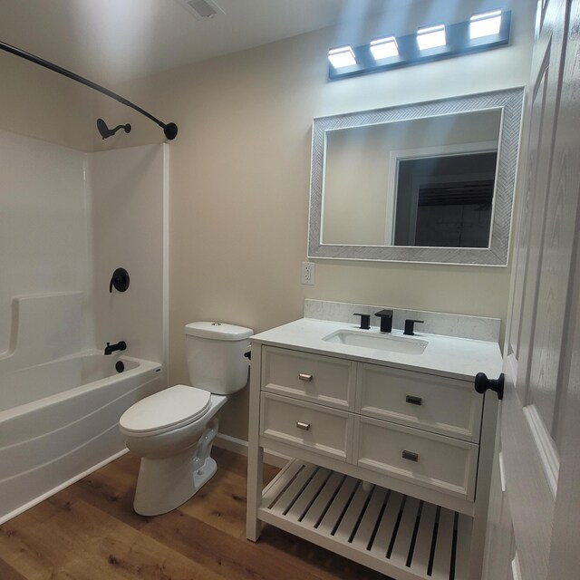 10781 Woodbrook Dr, Cement City, MI 49233 - bathroom with wood finished floors, vanity, and washtub / shower combination