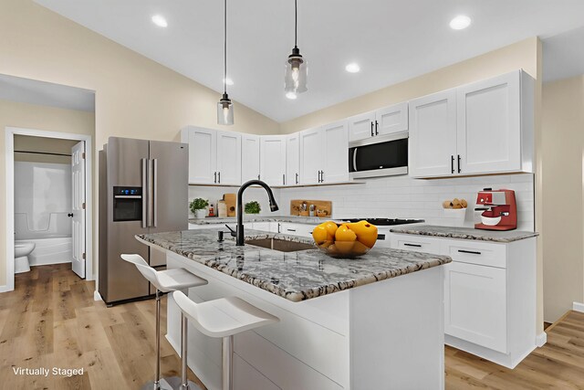 10781 Woodbrook Dr, Cement City, MI 49233 - kitchen featuring high end refrigerator, light stone counters, decorative backsplash, white cabinetry, and lofted ceiling