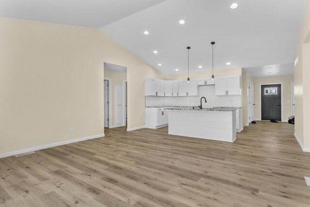 10781 Woodbrook Dr, Cement City, MI 49233 - kitchen with white cabinets, open floor plan, recessed lighting, a center island with sink, and vaulted ceiling